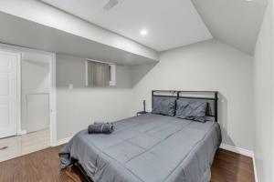 Un dormitorio con una cama grande en una habitación blanca. en Spacious 6BR Getaway Sleeps 16 Yard and Parking, en Brampton