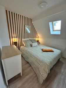 a bedroom with a large bed with a wooden headboard at La Parenthèse Picarde Maison de ville 2 chambres in Troissereux +35 photos