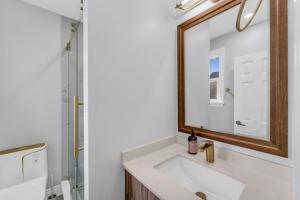 un baño con lavabo y espejo en Spacious 6BR Getaway Sleeps 16 Yard and Parking, en Brampton