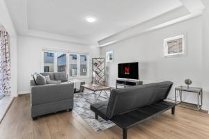 a living room with a couch and a tv at Luxury New Home By Niagara Fall in Fonthill