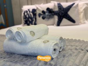 two rolls of paper towels sitting on a bed at Emunah Di Città Flats Ponta de Campina in Cabedelo