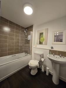 een badkamer met toilet, bad en wastafel bij Modern Stirling Apartment - Free Parking in Stirling