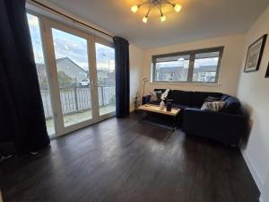 een woonkamer met een bank en een tafel bij Modern Stirling Apartment - Free Parking in Stirling