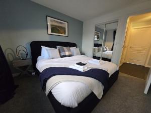 een slaapkamer met een groot bed met een spiegel bij Modern Stirling Apartment - Free Parking in Stirling