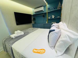 a hotel room with a bed and a tv at Emunah Di Città Flats Ponta de Campina in Cabedelo