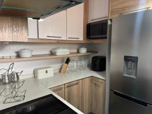 a kitchen with wooden cabinets and a stainless steel refrigerator at Davenport Durban in Durban