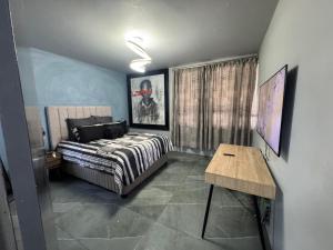 ein Schlafzimmer mit einem Bett und einem Tisch darin in der Unterkunft Davenport Durban in Durban