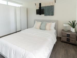 una camera da letto bianca con un letto grande e un tavolo di AQUA Terrazas Studio 4 - Oceanfront, Pool & Terrace Views a Mameyal