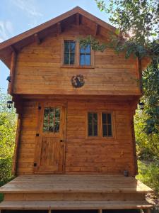Saint-OnésimeにあるLa Taniere du Renardの正面玄関と窓のあるログキャビン