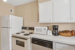 a white kitchen with a stove and a microwave at Downtown Atl Stay Cozy Comfort In Hotel District in Atlanta