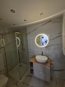 a bathroom with a sink and a shower and a mirror at Apartament Centrum in Kędzierzyn-Koźle