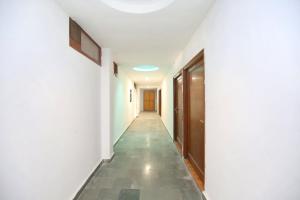 un couloir d'un immeuble avec des murs blancs et une porte dans l'établissement Hotel O Amaze Inn Indo Pak Bus Stand, à Amritsar