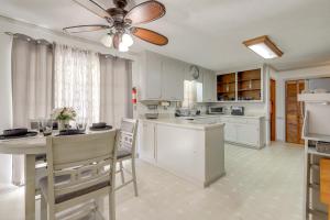 a kitchen with white cabinets and a ceiling fan at Playground and Grill Pet-Friendly Griffin Getaway! in Griffin