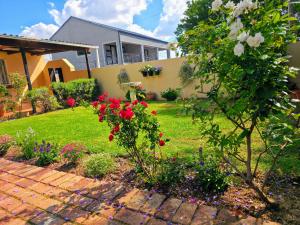 a house with a garden with red roses in the yard at Tau Golden Mane in Johannesburg