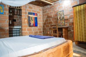 a bedroom with a bed in a brick wall at Le Jardin Secret in Ouidah