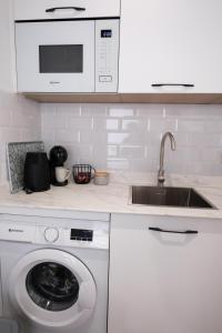 una cucina bianca con lavatrice e lavandino di La Zarzamora a Jerez de la Frontera