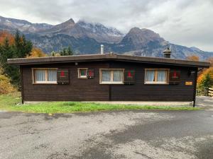 a small building with mountains in the background at Chalet Montana mit Bergblick in Brunig