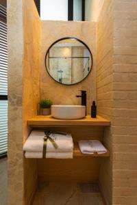 a bathroom with a sink and a mirror and towels at Hotel Boutique Obelisco in Medellín +16 photos