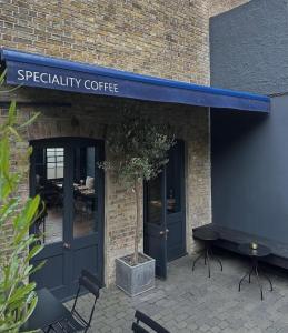 a coffee shop with a blue awning on a brick building at Smiths Townhouse in Broadstairs