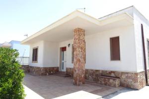 una casa con un muro di pietra e un pilastro di Casa Vacanze Mareblù ad Alliste