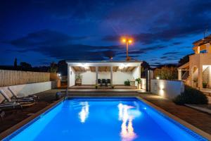 a swimming pool in the backyard of a house at night at My Dalmatia - Villa Marijana in Radonić