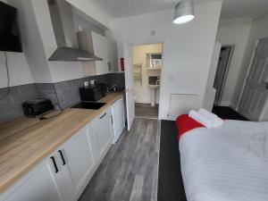 Una cocina con gabinetes blancos y un sofá rojo en ella. en Fishpond Family Suite, en Moffat 8 fotos más