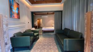 a room with two green chairs and a bed at Mango Lantern Villa by Mirth, Kollam in Perumanseri +11 photos