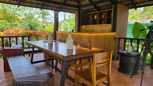 a wooden table and chairs on a patio at Mango Lantern Villa by Mirth, Kollam in Perumanseri