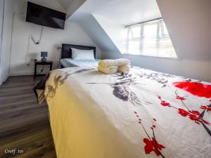 a bedroom with a bed with a flowery blanket on it at En-suite 6 Woodhouse, private bath, 2 kitchen in Stoke on Trent