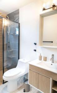 a bathroom with a toilet and a sink and a mirror at Villas Del Mar 1 Steps to Beach Prime Location in Mameyal