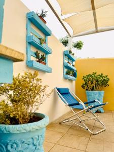 una sedia blu appoggiata su un patio con piante in vaso di Casa Vacanze Mareblù ad Alliste