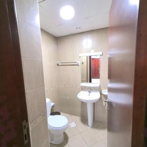 a bathroom with a white toilet and a sink at Family-Friendly, Near to Beach, Near Shops & Parks, City View in Ajman  +4 photos