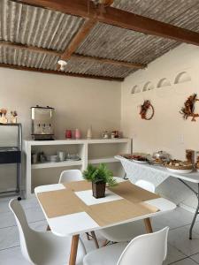 een eetkamer met een tafel en stoelen en een keuken bij Vilacessivel Pousada in Porto De Galinhas