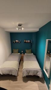 three beds in a room with a blue wall at Royal sleeping Brussels in Brussels