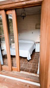 a small bedroom with a bed in a room at Pousada Minha Rosa Paixão - PRAIA DO ROSA, SC in Imbituba