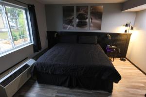 a bedroom with a bed in a room with a window at Plymouth Suites in Plymouth
