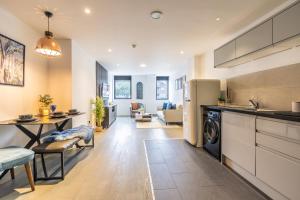 cocina y sala de estar con mesa y nevera en Stylish Apartment With Parking Close To Birmingham, en Birmingham