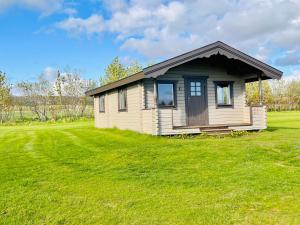 a small house in a field with a green yard at Hellisholar Cottages in Hvolsvöllur +41 photos