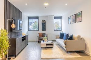 Una sala de estar con un sofá y un televisor. en Stylish Apartment With Parking Close To Birmingham, en Birmingham
