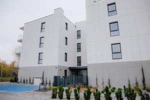 a white building with a pool in front of it at Lubelski Kadr in Lublin