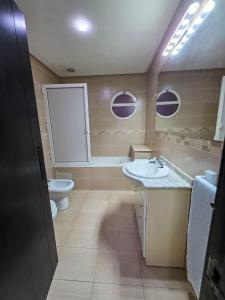 ein Badezimmer mit Waschbecken, Toilette und Spiegel in der Unterkunft Fade House in Temara