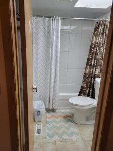 une salle de bain avec toilettes et rideau de douche dans l'établissement Master bedroom in a quiet and smoke-free home, à Winnipeg