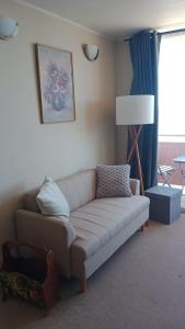 a living room with a couch and a lamp at departamentoplaya in Tomé