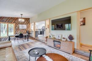 a living room with a couch and a fireplace at Riverbend Retreat on 7 Acres with River Access! in Webster