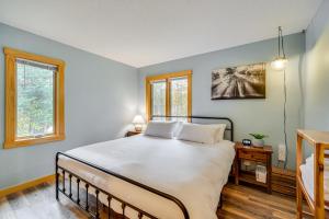 a bedroom with a large bed and two windows at Riverbend Retreat on 7 Acres with River Access! in Webster