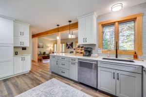 a large kitchen with white cabinets and a window at Riverbend Retreat on 7 Acres with River Access! in Webster