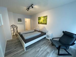 Un dormitorio con una cama y una silla dentro. en Ferienwohnung Nelly, en Wermelskirchen