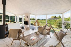 a living room with a table and chairs at 20225-Samso-Rosenvej-9 in Tanderup