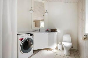 a white laundry room with a washing machine and a toilet at 20225-Samso-Rosenvej-9 in Tanderup