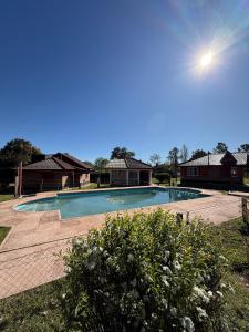 a large swimming pool in a yard with houses at Cabañas Lomas del mirador in Villa del Dique